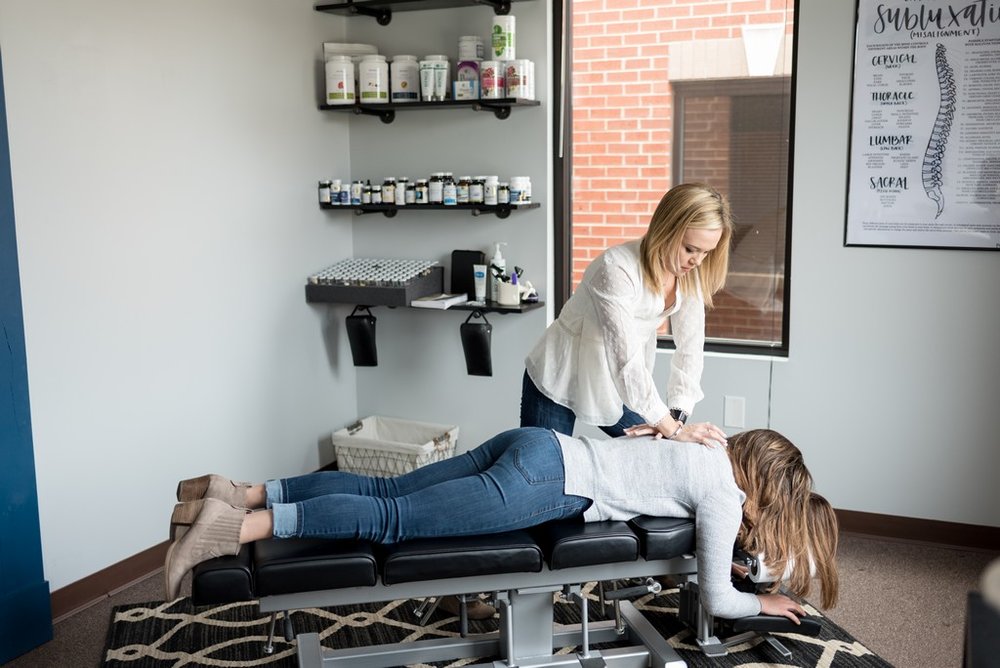 Brand photo of woman chiropractor adjusting a client at her chiropractor office in Franklin, TN.
