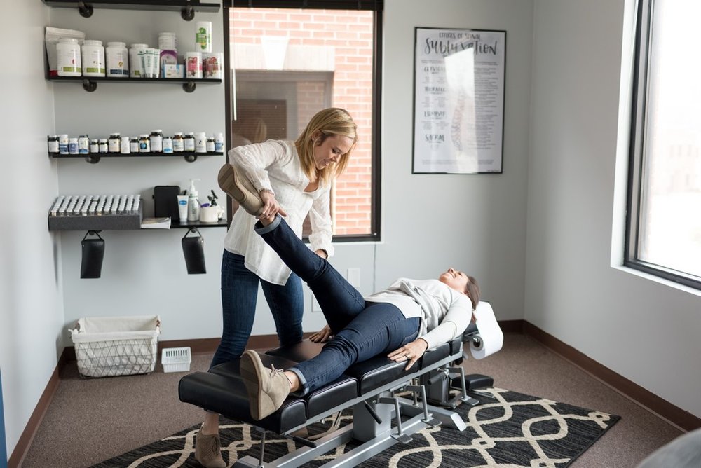 Brand photo of woman chiropractor adjusting a female client at her chiropractor office in Franklin, TN.