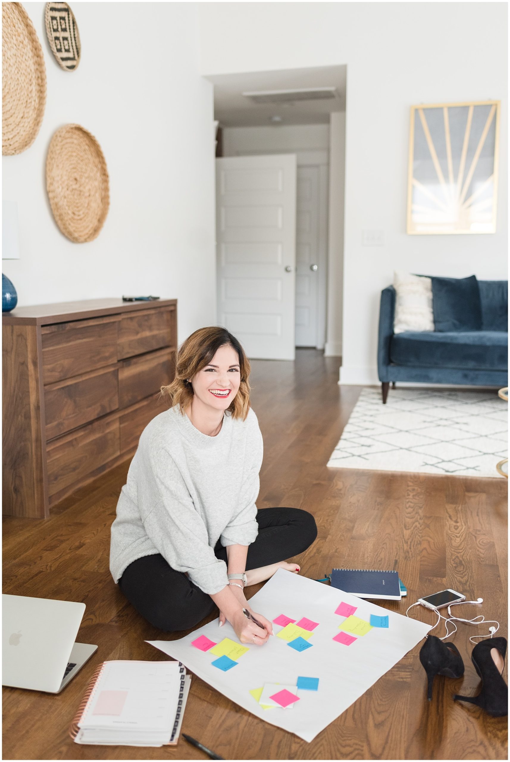 woman business owner sitting on the floor with a white poster board and post-its for a brand photoshoot in Nashville